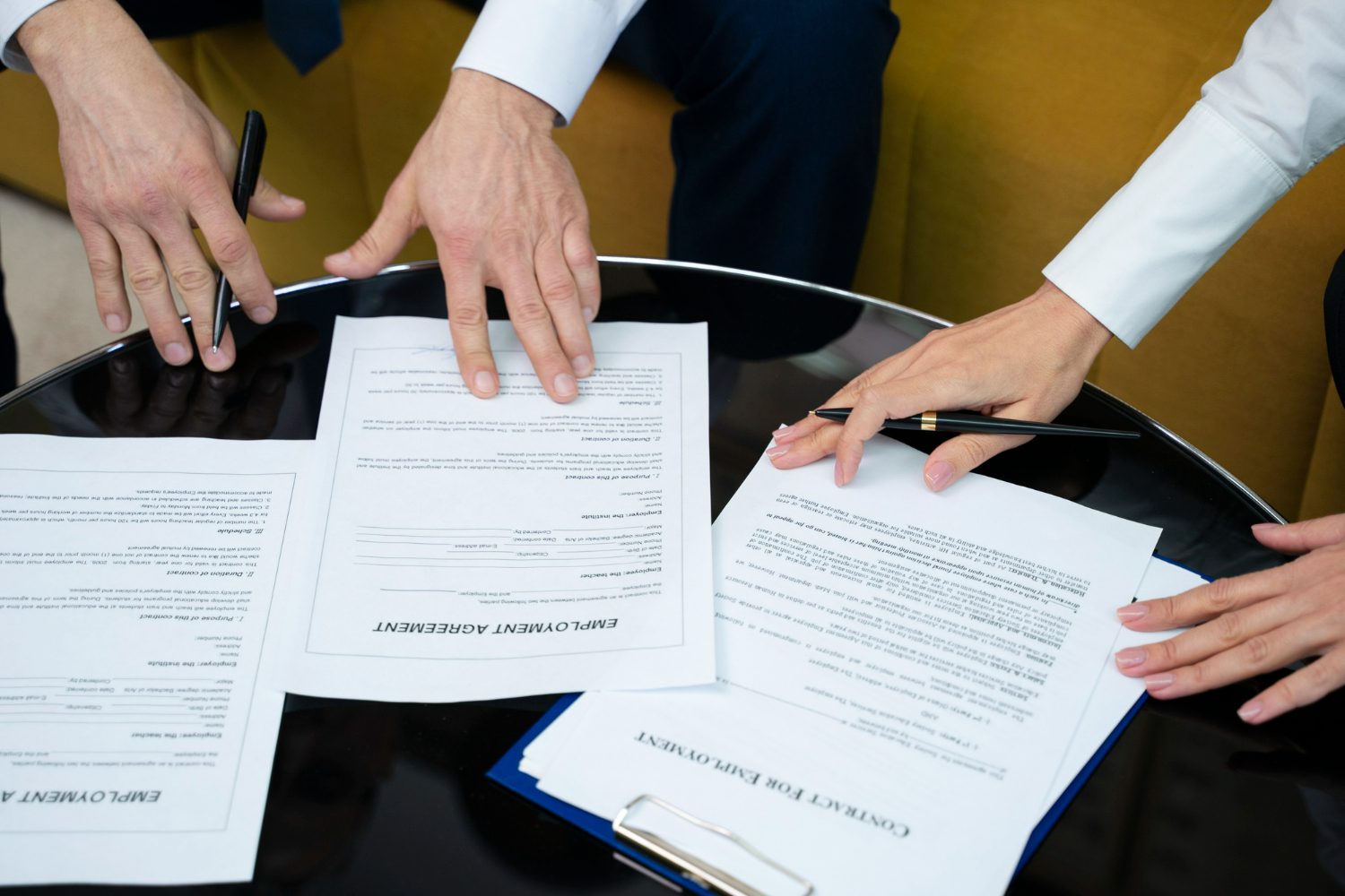 high-angle-hands-signing-documents