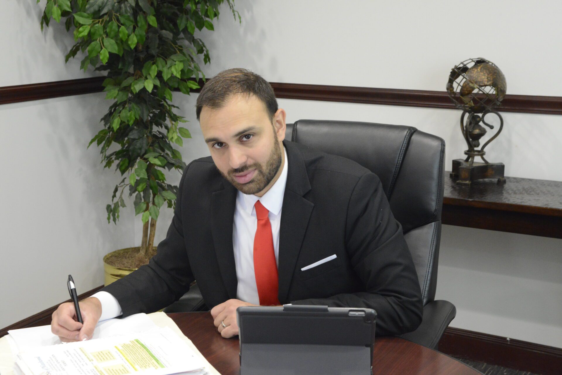 Ben Keathley signing a document at his desk